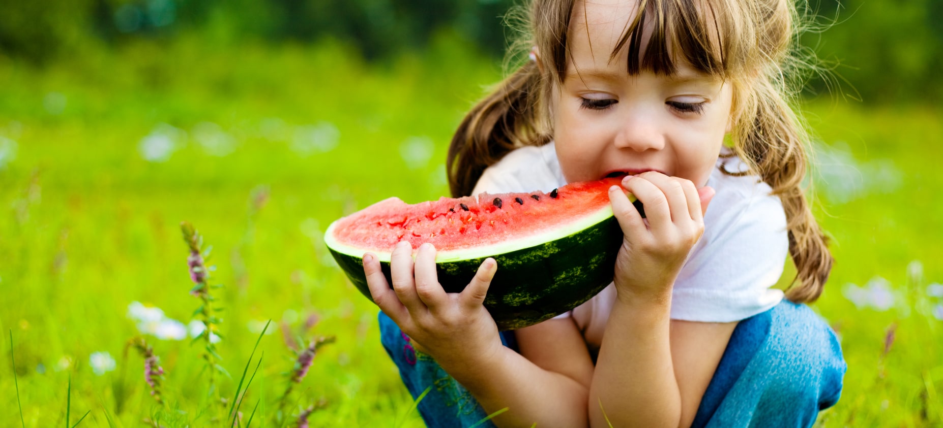 Child enjoying watermelon at a camp event